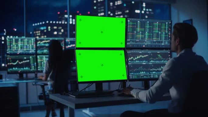财务分析师在计算机上工作，该计算机具有带有绿屏色度键模拟模板和实时股票图表的多显示器工作站。商人在傍