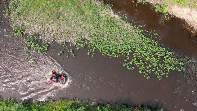 驾驶四轮摩托穿过河流的鸟瞰图