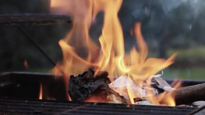 用火在烧烤架上燃烧的纸。特写。放大。黑白到彩色。