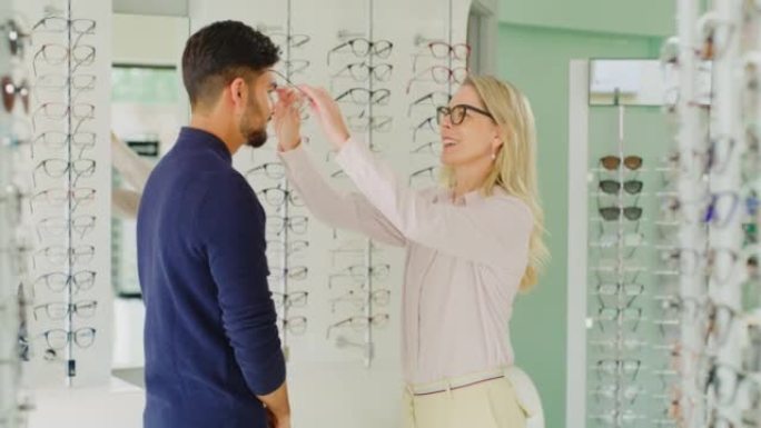 配镜师帮助客户在验光时选择眼镜。在眼镜店咨询验光师配镜的男性顾客，以提高视力