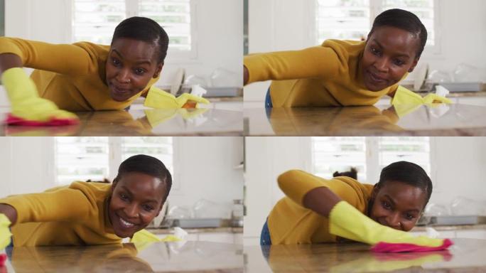 快乐的非洲裔美国女性清洁厨房台面