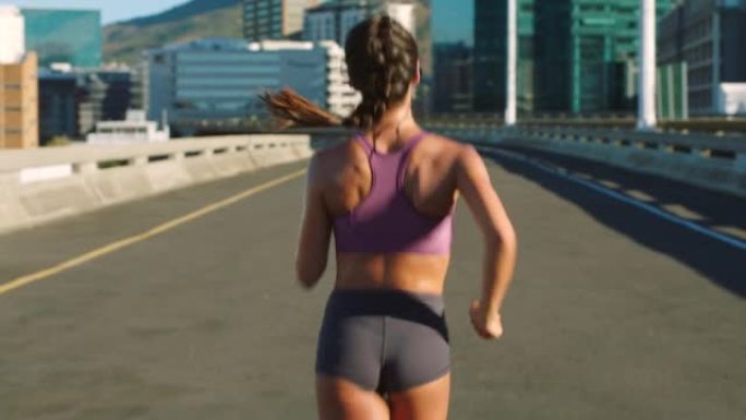 健身女性，城市跑步者，并在城市桥梁的道路上进行训练，从后面进行有氧运动。跑步时的运动动机和运动锻炼，