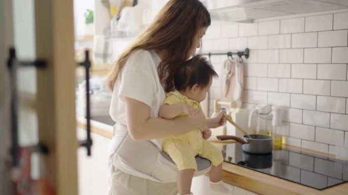 妈妈准备午餐，抱着女儿。