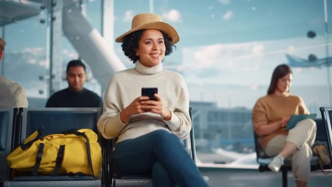 机场航站楼: 快乐的黑人妇女等待航班，使用智能手机，浏览互联网，在社交媒体上发帖，在线购物。在航空枢