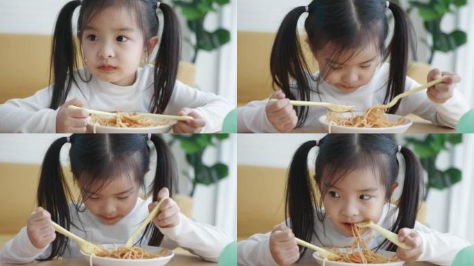 年轻的亚洲女孩喜欢吃意大利面，一个小女孩的肖像吃意大利面配沙拉、西红柿、西兰花和红酱