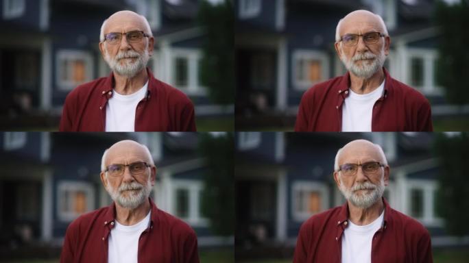 近距离拍摄一位戴着眼镜的开朗的老人的肖像，他戴着眼镜站在居民区房屋前的户外。退休的成年男子看着相机微
