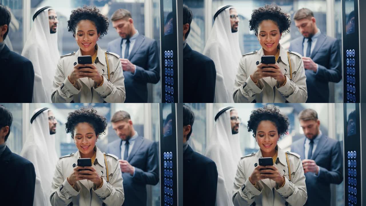 四个不同的多民族国际人士乘坐玻璃电梯在现代商务中心办公。专注于年轻时尚的黑人拉丁女商人在电梯中使用智
