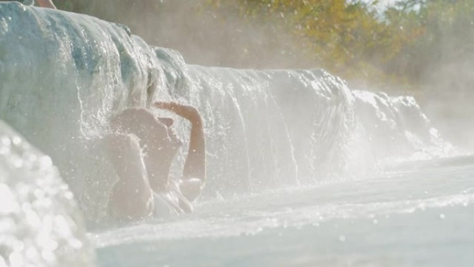 托斯卡纳土星温泉的超级SLO MO女人在自然游泳池放松