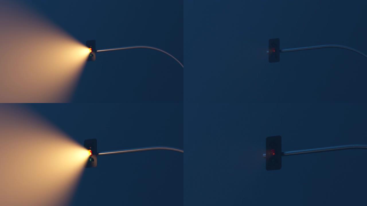 黑暗雾蒙蒙的街道上的灯杆上有光束的交通信号灯