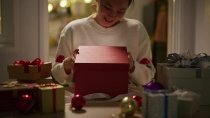快乐亚洲女人打开礼品盒