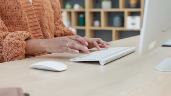 女人坐在办公桌前并在现代办公室发送电子邮件时，双手在键盘上打字的特写镜头。记者为一篇文章做在线研究。