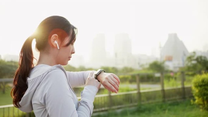 早上在城市使用智能手表的运动女性