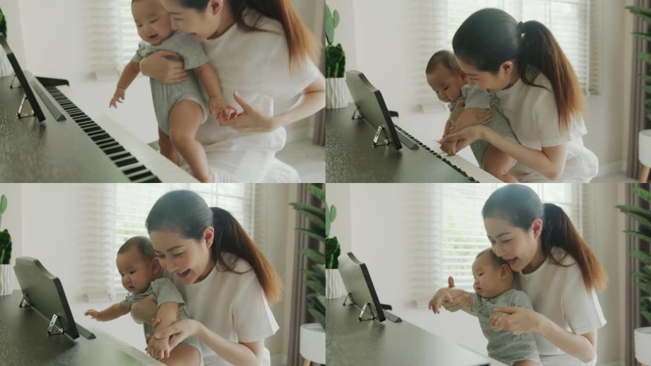 关闭亚洲母亲在家里教她的新生儿弹钢琴。男婴学习钢琴以发展大脑和情绪控制能力