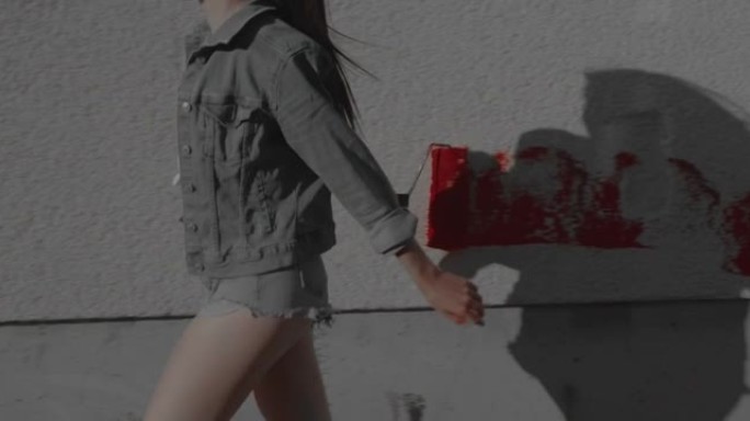女人走路用红色油漆滚筒粉刷墙壁