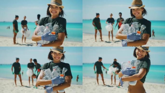 一位戴着帽子的年轻黑发女志愿者的慢动作在镜头前微笑着，满足于在大海的海滩上捡起塑料垃圾以保护环境。