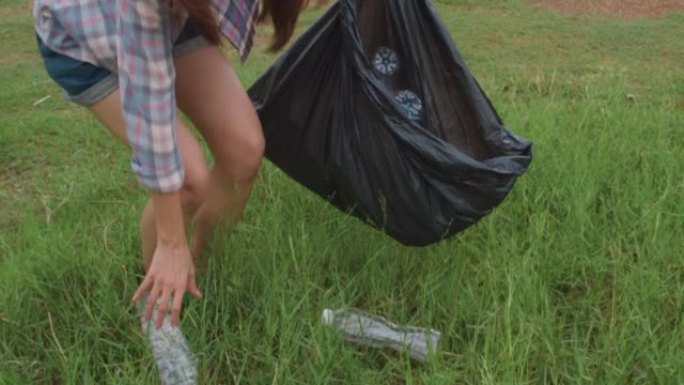 快乐的年轻亚洲活动家在海滩上收集塑料垃圾。