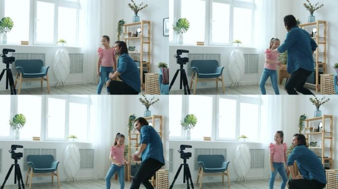 父亲和孩子的博客们跳舞和挥舞着手，就像为摄像机摆姿势一样