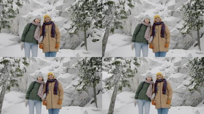 站在冬日树林享受旅程的快乐年轻男女慢动作肖像