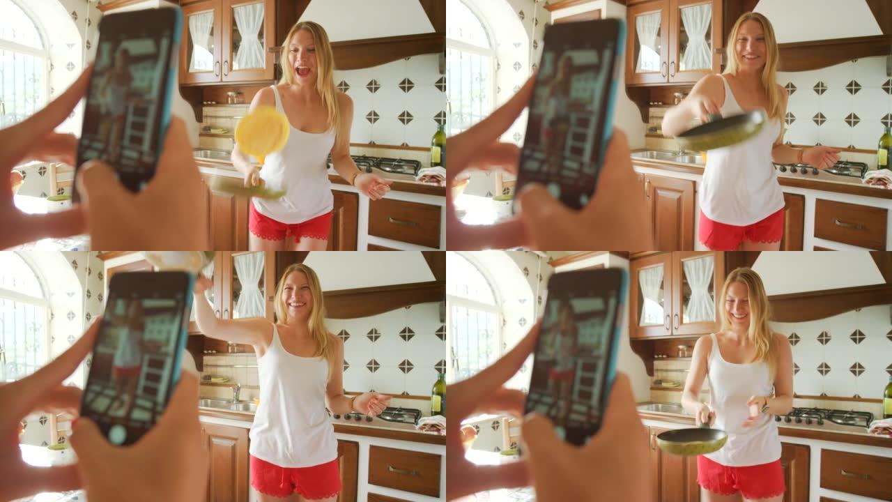一个兴奋的年轻女子在用手机拍照时翻转煎饼