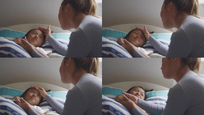 亚洲母亲在睡觉前与生病的女儿在床上说话