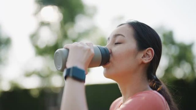 女人用可重复使用的水瓶喝水