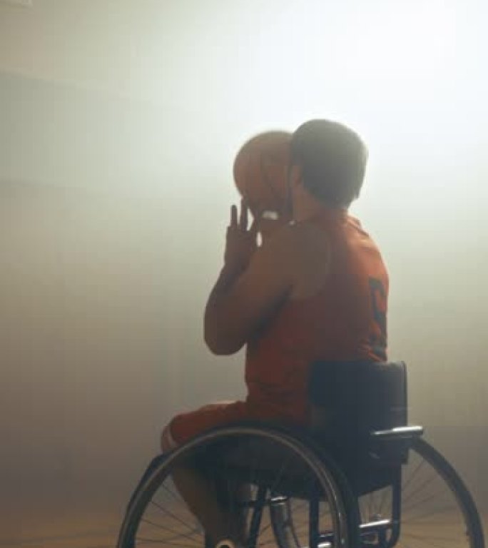 垂直视频。轮椅篮球运动员运球，射门成功，打进完美进球。确定残疾人行动迅速，得分。玩赢