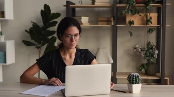 专注的女商人使用笔记本电脑与公司客户相对应