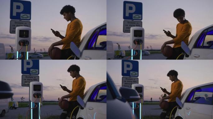SLO MO Young篮球运动员在黄昏时在停车场上充电电动汽车