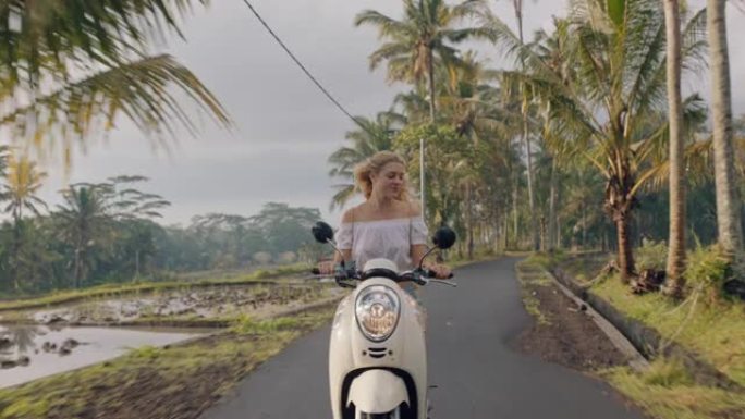 热带岛屿公路旅行骑摩托车的年轻女子享受旅行假期骑摩托车4k