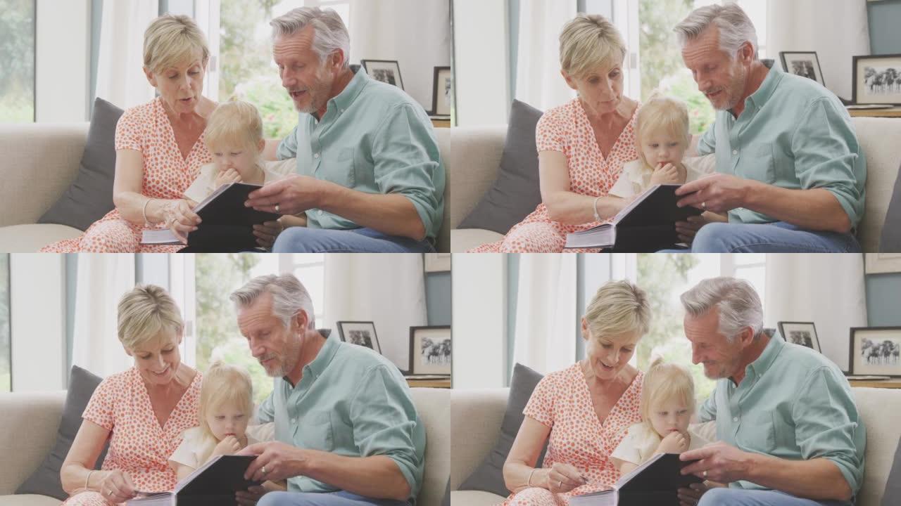 祖父母坐在沙发上，孙女在家一起看相册
