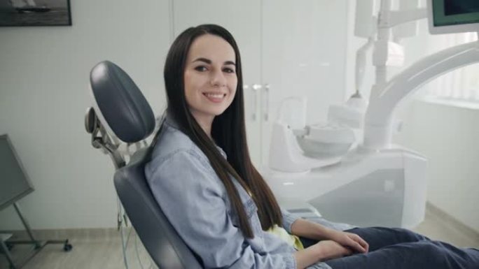 SLO MO肖像，一个快乐的年轻女子在牙医的椅子上等待