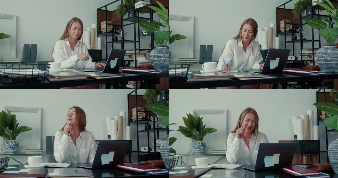 生活平衡的概念。快乐成功的白人商业女性使用笔记本电脑，在现代办公室做笔记和思考