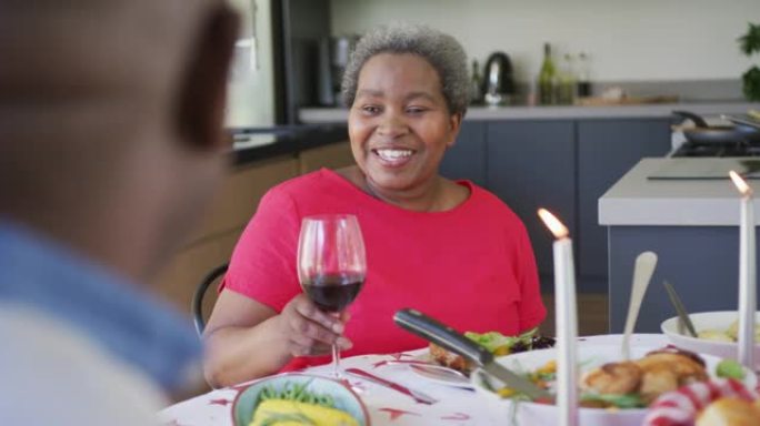 快乐的非洲裔美国高级女性在厨房与伴侣用餐