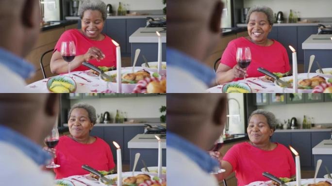 快乐的非洲裔美国高级女性在厨房与伴侣用餐