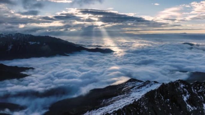太阳刺穿云层，照亮雪山和云海