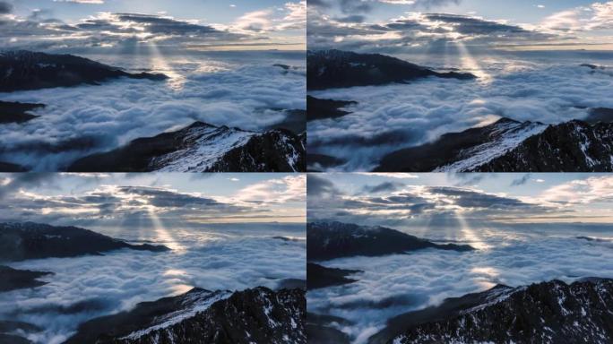 太阳刺穿云层，照亮雪山和云海