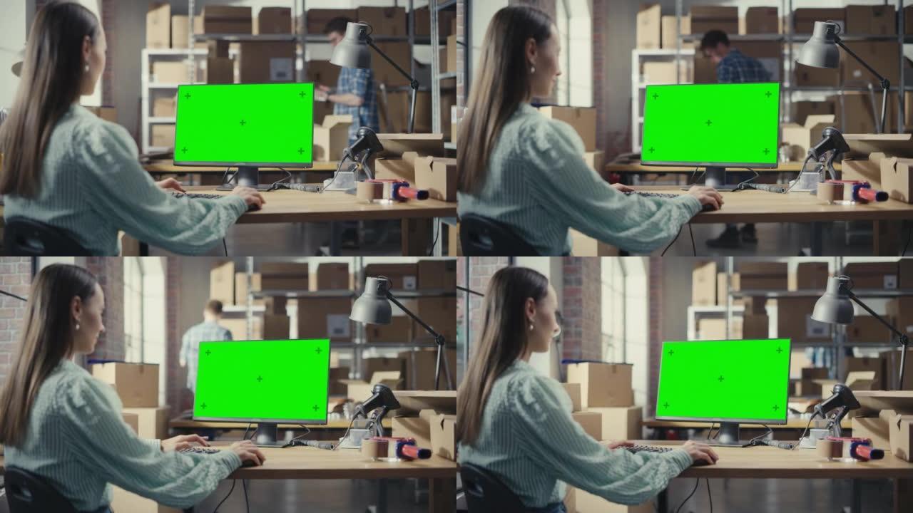 女人使用带有绿屏Chromakey模拟显示器的台式计算机。分销经理和在分销仓库工作的员工用纸箱。在肩
