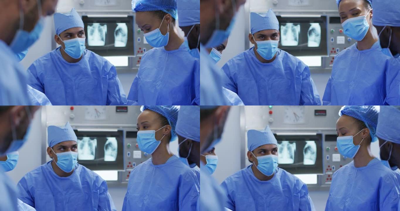 混血外科医生穿着防护服在手术室讨论
