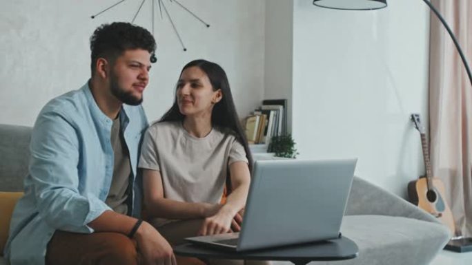 年轻的拉丁夫妇在笔记本电脑上聊天