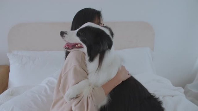 年轻的亚洲女孩抱着爱躺在床上亲吻她的宠物。