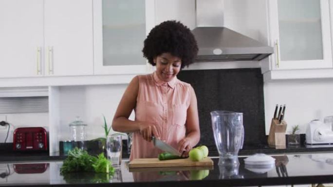 非裔美国妇女在家中厨房切蔬菜