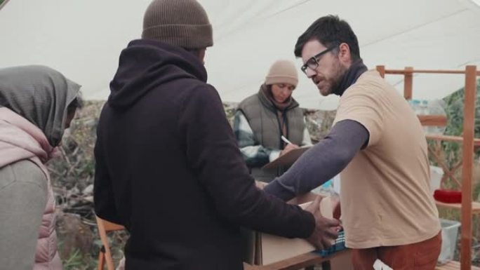 难民接受社会工作者的食物和衣服