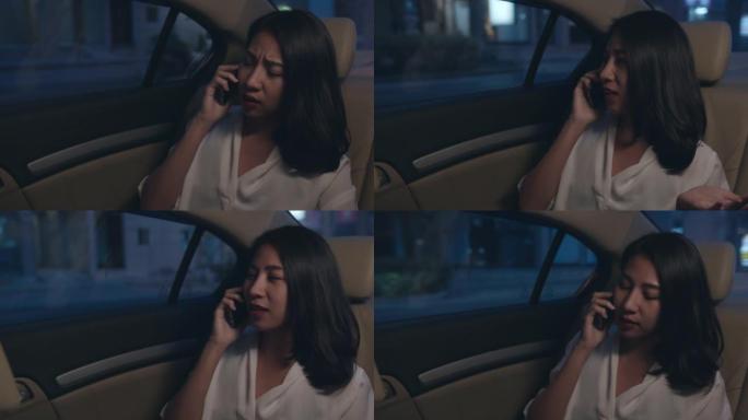 穿着时尚办公服装的亚洲女商人深夜在城市现代城的汽车后座上聊天智能手机。