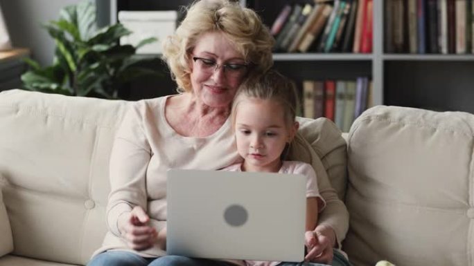 小学前班和中年奶奶在笔记本电脑上玩游戏。