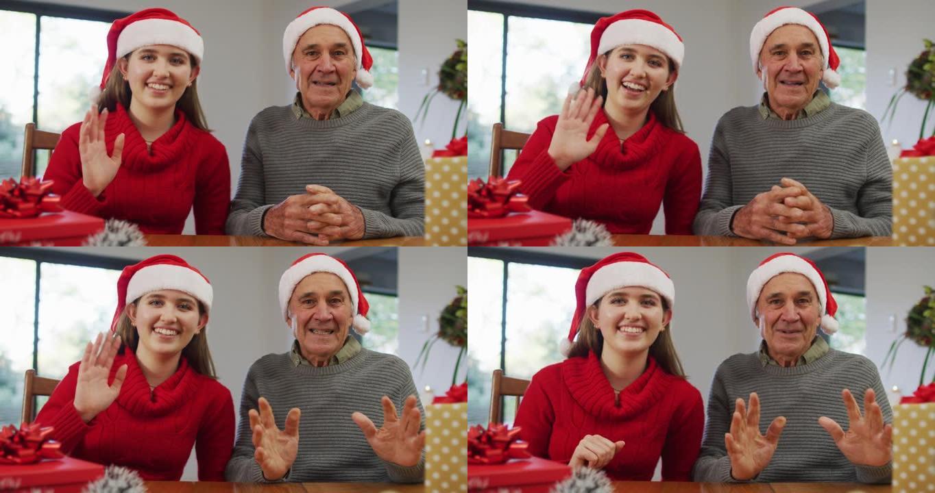快乐的高加索资深父亲和成年女儿戴着圣诞老人的帽子在家打视频电话