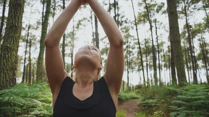 女运动员在绿色森林中冥想和锻炼瑜伽