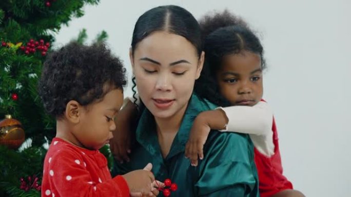 年轻女子与被收养的非洲裔美国小女孩，年龄3岁，在家里享受圣诞节的乐趣。现代父母身份: 收养概念。