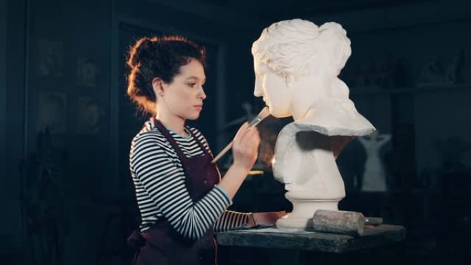 女艺术家正在刷石膏雕塑