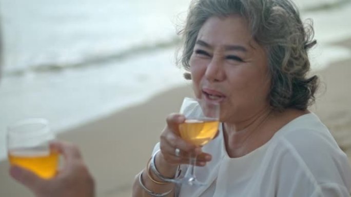 SLO MO成熟夫妇在海滩上喝酒