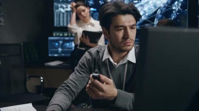 一个穿着毛衣的男人在电脑上工作